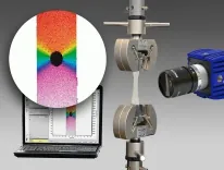 En enhet måler stress på et materialstykke, og resultatene vises på en dataskjerm med et fargekart som indikerer stresspunkter.
